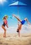 Couple of pole dancers playing volleyball on the beach, creative concept