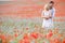 Couple in poppy field embracing and smiling