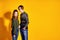 Couple posing in jeans type commercial fashion style on yellow wall