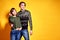 Couple posing in jeans type commercial fashion style on yellow wall