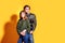 Couple posing in jeans type commercial fashion style on yellow wall