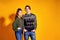 Couple posing in jeans type commercial fashion style on yellow wall