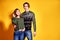 Couple posing in jeans type commercial fashion style on yellow wall