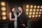 Couple posing near stage and many lamp. Luxury and richly concept.