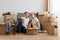 Couple posing in a new apartment after relocating, husband feels tired and sleeping and sitting with closed eyes, wife being