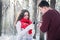 Couple pours hot tea out of thermos in winter forest