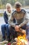 Couple Preparing Bonfire During Lakeside Camping