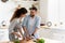 Couple preparing together vegetable salad standing in kitchen at home