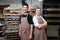 Couple of proud workers, male and female posing for a photo in a bakery kitchen