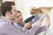 Couple Putting Up Wooden Shelf Together At Home