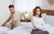 Couple in quarrel concept. Offended wife sitting on bed