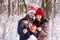 Couple in red hats holding gift and bengals outdoors