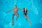 Couple refreshing in the swimming pool on the turquoise water at vacation. They are floating on the surface