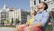 Couple relaxing on bench enjoying sun with eyes closed in city square in Madrid