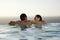 Couple Relaxing In Infinity Pool At Resort