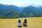 Couple Relaxing on the Meadow of Highland Farm Admiring Awesome View of Caucasus Mountain, Mestia, Svaneti Region, Georgia