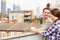 Couple Relaxing Outdoors On Rooftop Garden Drinking Coffee