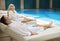 Couple relaxing by the poolside wearing toweling robes