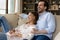 Couple relaxing on sofa laughing spend carefree weekend at home