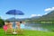 Couple relaxing on sun loungers near river and mountains. Luxury vacation