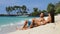 Couple relaxing on suntan beach vacation holiday - Happy young adults sunbathing