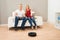 Couple With Remote Control And Robotic Vacuum Cleaner