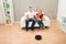 Couple With Remote Control And Robotic Vacuum Cleaner