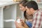 couple repairing pipe under sink in kitchen