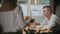 A couple in restaurant having a lunch - waiter brings them an order