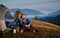 Couple resting in campsite in mountains at sunny autumn.