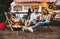 Couple resting near trailer. Camping season