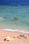 A couple is resting at the seaside. Clothes left on a sandy beach, sea waves with white foam and two friends are going to swim in