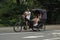 A couple ride a rickshaw through Central Park