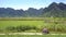 Couple rides motorbike on trail meandering among fields