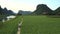 Couple rides scooter along rural road among fields aerial