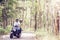 Couple riding their scooter through forest