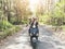 Couple riding their scooter through forest