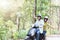 Couple riding their scooter through forest