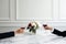 Couple on romantic date. Friends clinking glasses, side view. Red wine, flowers around on marble table. Wedding celebration, party