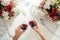 Couple on romantic date. Friends clinking glasses, top view. Red wine, flowers around on wooden table. Wedding celebration, party