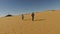 Couple running barefoot in desert, Egypt