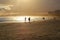 Couple running on the beach sand at dusk. Silhouettes of person in the strong sunset light