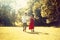 Couple running in the forest , field. Girl in a long red dress and hat, stylishly dressed man. Sunset in the park. The girl