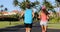 Couple running and jogging in rich beautiful neighborhood on summer day