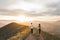 Couple running together by sunset hill with amazing mountain view