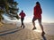 Couple runs through city park by lake shore