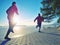 Couple runs through city park by lake shore