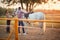 Couple saddling a horse at  ranch for ride at sunset
