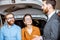 Couple with sales manager near the car in the showroom