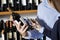 Couple Scanning Barcode On Wine Bottle Through Smartphone